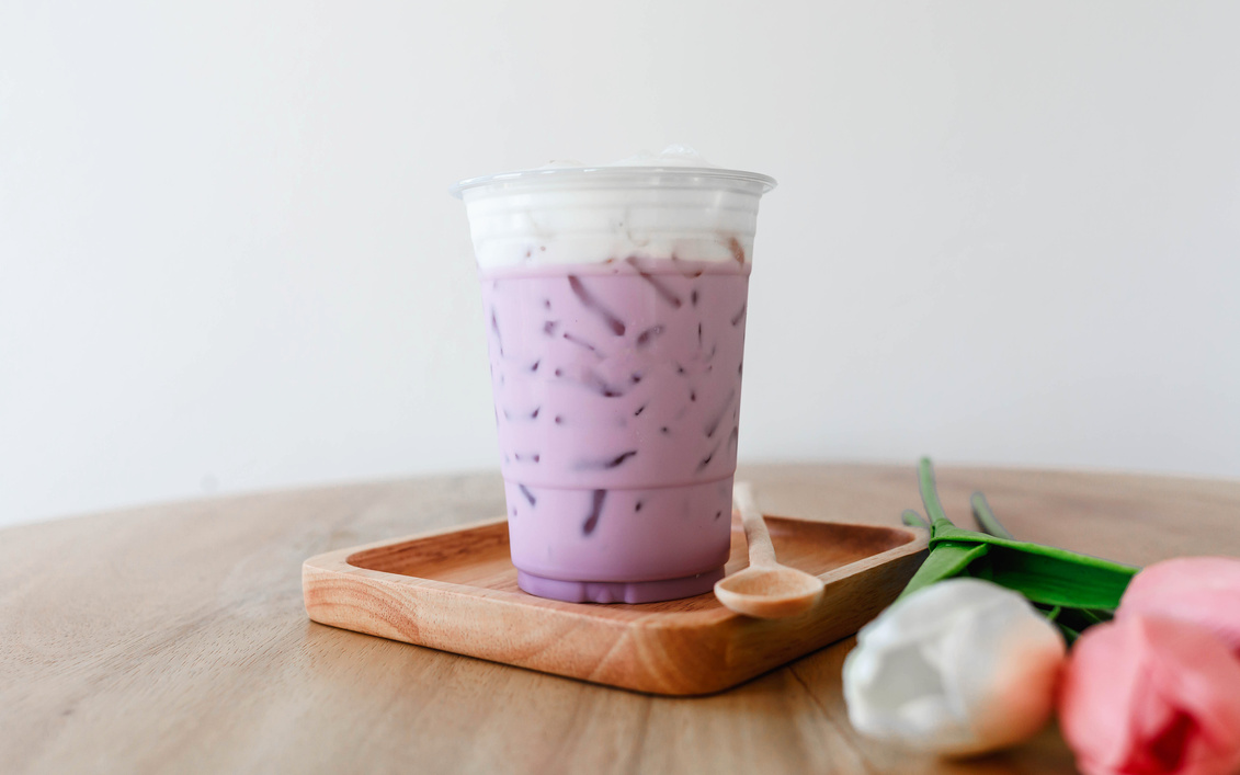 Iced taro tea with milk in a plastic cup
